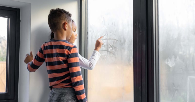 Little kids playing tic tac toe on a window