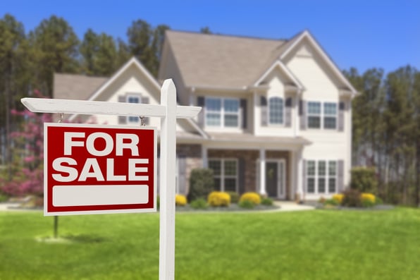 A for sale sign outside a white two-story home with excellent curb appeal. 